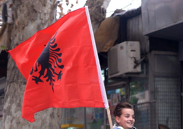 Ragazzino albanese con la bandiera nazionale © EPA