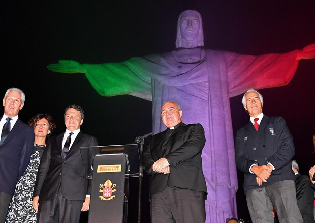 Matteo Renzi sotto la statua del Cristo Redentore illuminata con i colori della bandiera italiana (foto: ANSA)