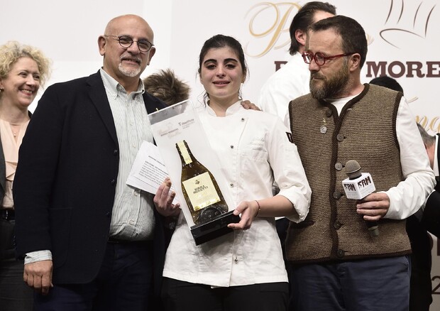 La chef Solaika Marrocco (c) riceve dallo chef Claudio Sadler (s) e dallo chef Giancarlo Morelli (d) il Premio Birra Moretti Grand Cru © ANSA