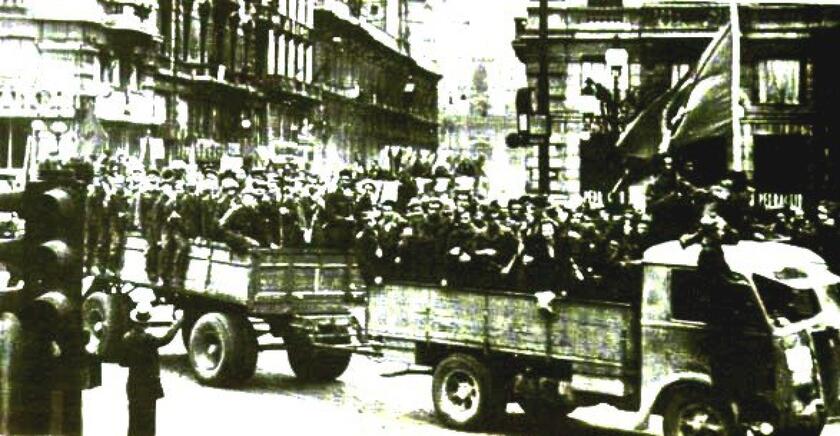 Partigiani sfilano su automezzi per le strade di Bologna dopo la liberazione /WIKIPEDIA