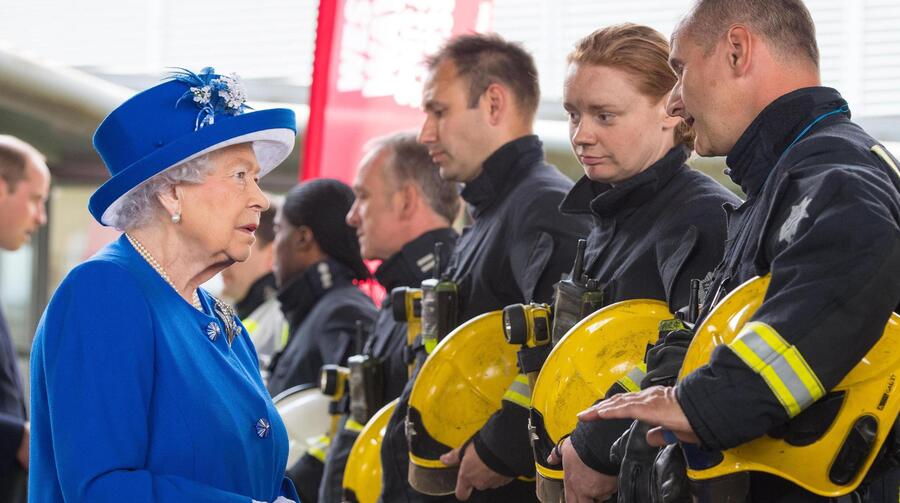 La regina Elisabetta saluta i vigli del fuoco che hanno spento le fiamme della Grenfell Tower © Ansa