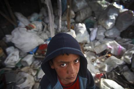Palestinian children collect plastics and metals in the junk waste in the town of Beit Lahiya, in north Gaza Strip