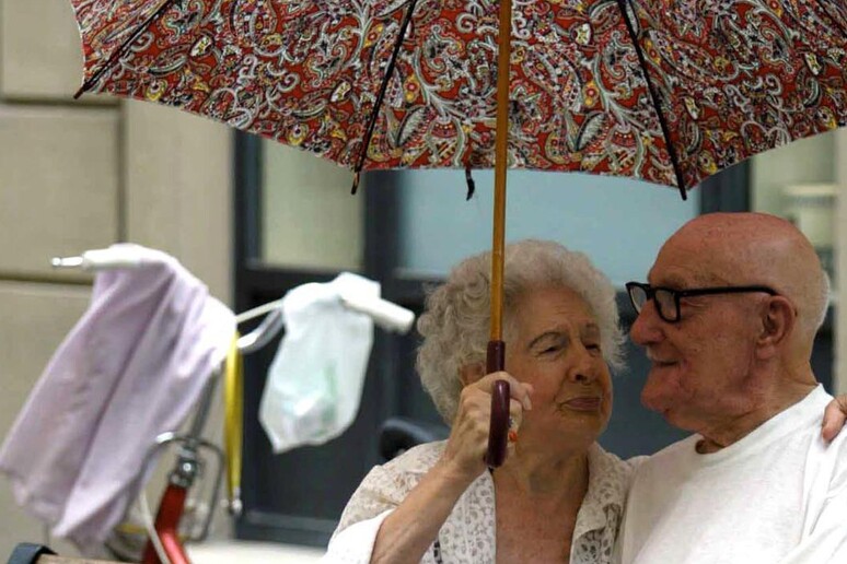 Una coppia di anziani si ripara dal sole con un ombrello - Archivio - RIPRODUZIONE RISERVATA
