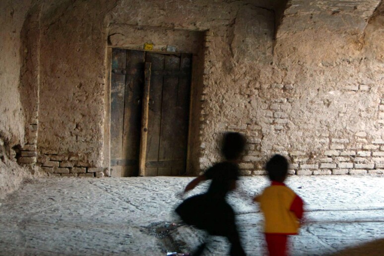 Due bambini corrono in un vicolo in una foto d 'archivio - RIPRODUZIONE RISERVATA