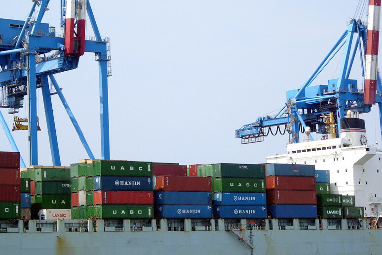 Un 'operazione di carico di container nel porto di Genova - RIPRODUZIONE RISERVATA