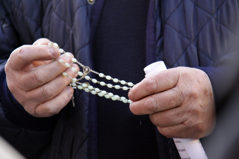 Un sacerdote recita il rosario - RIPRODUZIONE RISERVATA