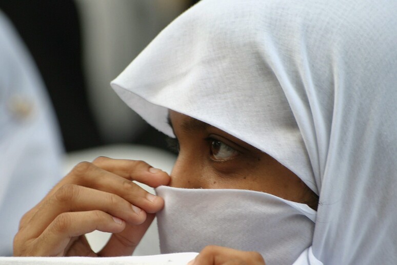Una donna musulmana si copre il viso con il velo - RIPRODUZIONE RISERVATA