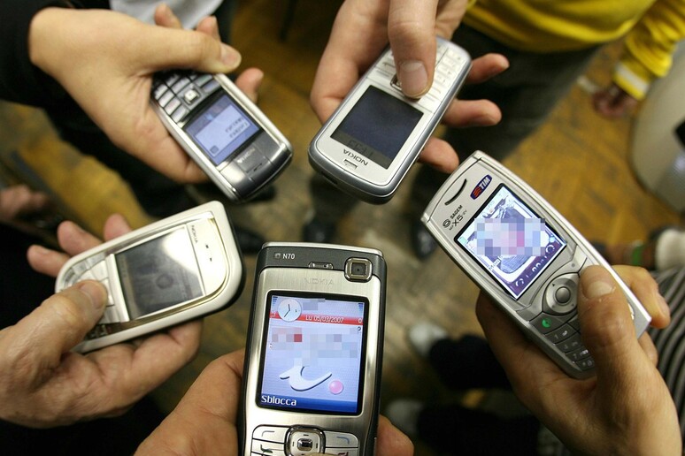 Ragazzi posano per una foto con i loro telefoni cellulari - RIPRODUZIONE RISERVATA