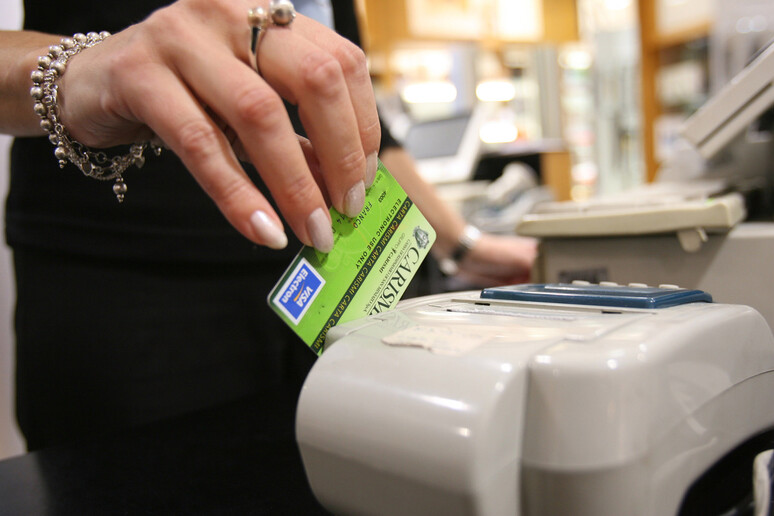 Una signora durante un pagamento con il bancomat in un 'immagine d 'archivio. - RIPRODUZIONE RISERVATA