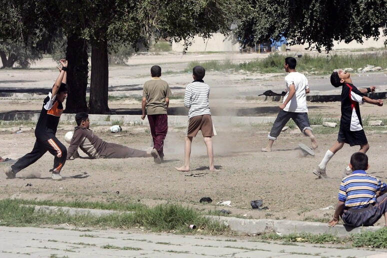 Ragazzi giocano a calcio in Iraq - RIPRODUZIONE RISERVATA