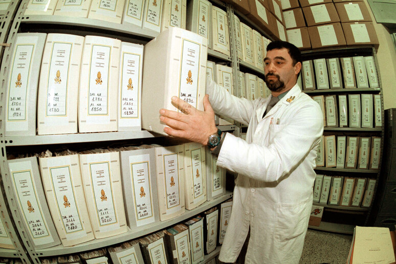 Un agente della guardia di Finanza mentre cerca tra fascicoli in un 'immagine d 'archivio del 4 aprile  2004. ANSA/ FRANCO SILVI - RIPRODUZIONE RISERVATA