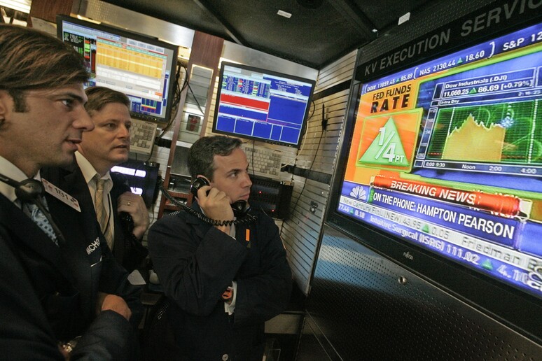 Operatori di borsa seguono in tv la notizia dell 'aumento dei tassi di interesse deciso dalla Fed © ANSA/AP