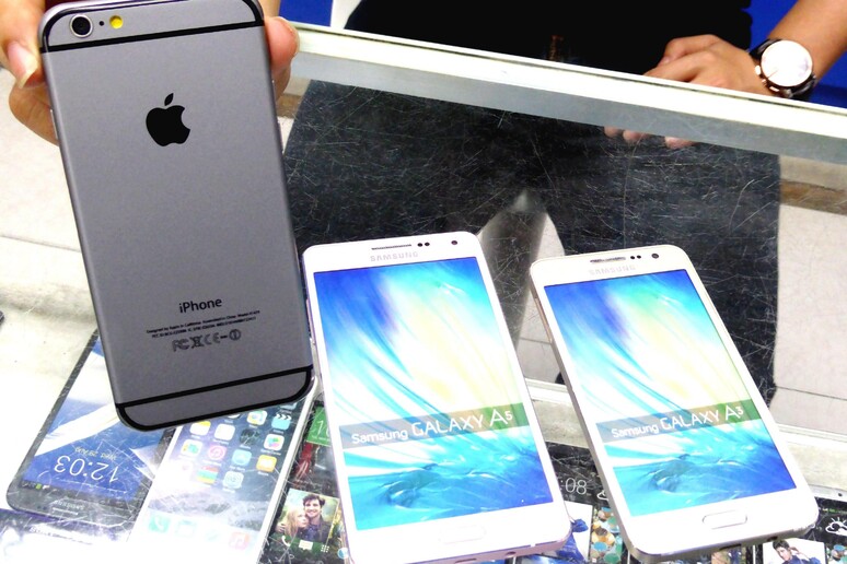 Un commesso mostra uno smartphone iPhone 6 a un cliente a Taipei - RIPRODUZIONE RISERVATA