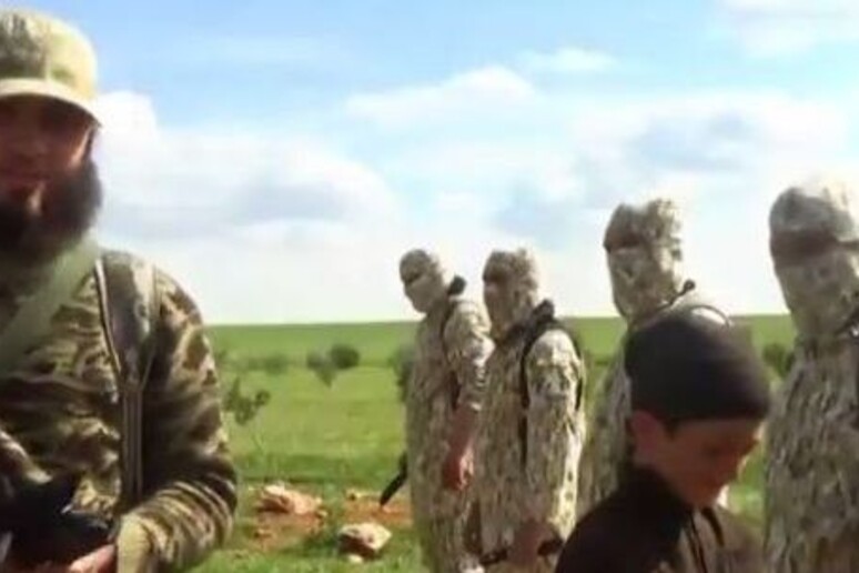 Un frame del video dell 'Isis in cui un bimbo consegna i coltelli ai jihadisti - RIPRODUZIONE RISERVATA