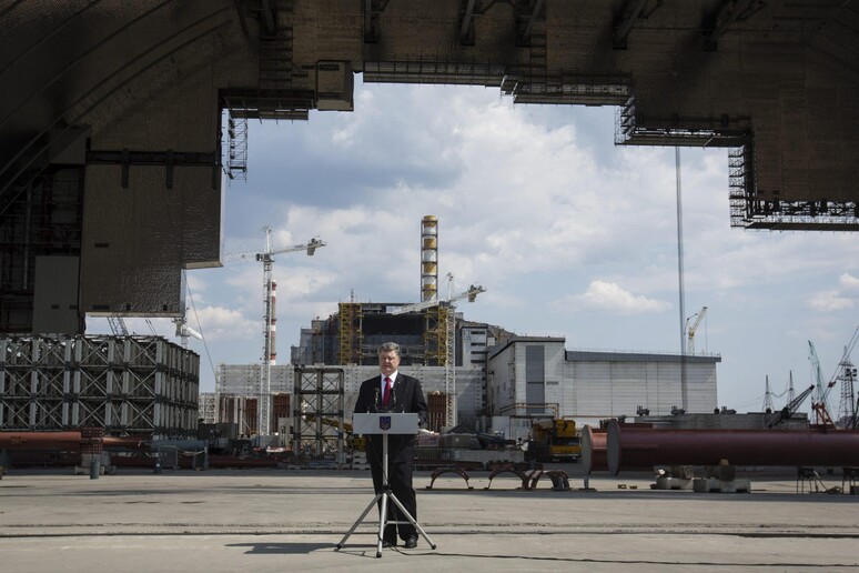 Il presidente ucraino, Petro Poroshenko, parla davanti al cantiere del "sarcofago" per sigillare la centrale nucleare di Chernobyl © ANSA/EPA
