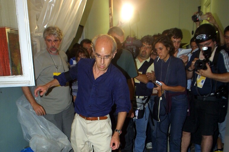Vittorio Agnoletto, accompagnato dall 'attore Ricky Tognazzi, percorre un corridoio macchiato di sangue, dopo la perquisizione di polizia e carabinieri nella scuola Diaz (archivio) - RIPRODUZIONE RISERVATA