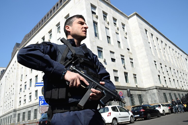 Un agente di polizia armato all 'esterno di Palazzo di Giustzi a Milano - RIPRODUZIONE RISERVATA