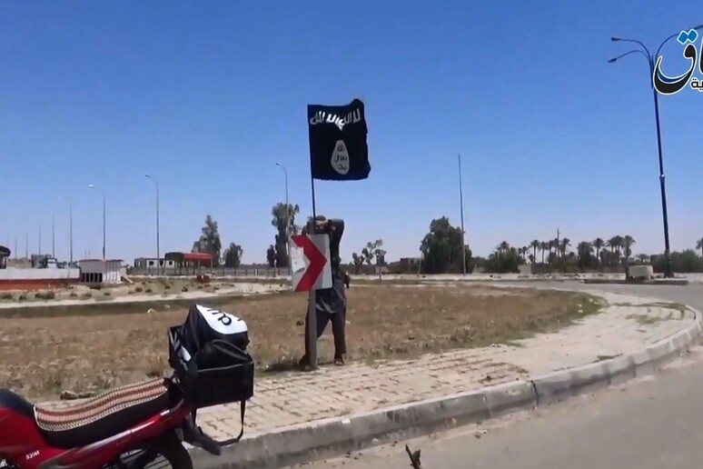 Nella foto d 'archivio un militante dell 'Isis pianta la bandiera del gruppo jihadista a Ramadi - RIPRODUZIONE RISERVATA