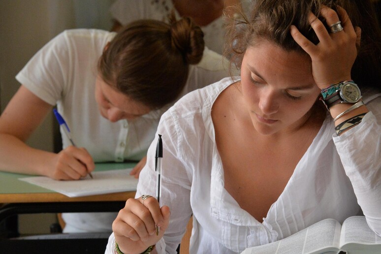Una studentessa durante la prima prova dell 'esame di maturita ' in una foto d 'archivio - RIPRODUZIONE RISERVATA