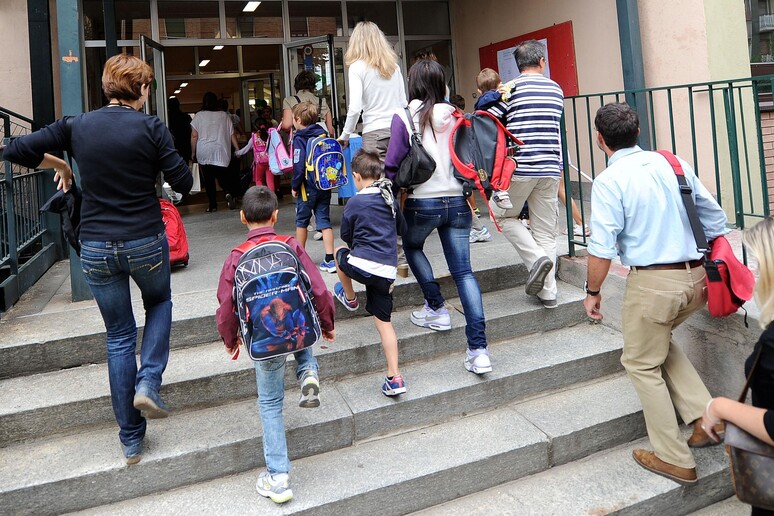 Studenti entrano in una scuola, in una immagine di archivio - RIPRODUZIONE RISERVATA