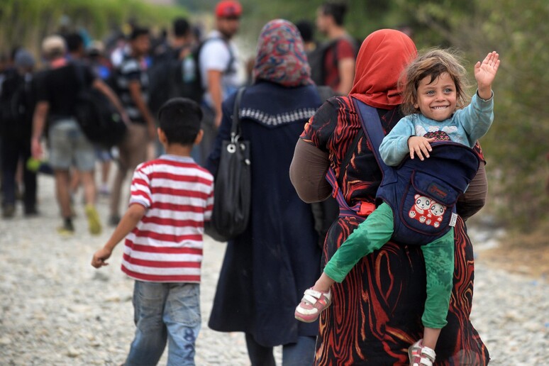 Rifugiati che attraversano il confine tra Macedonia e Grecia © ANSA/EPA