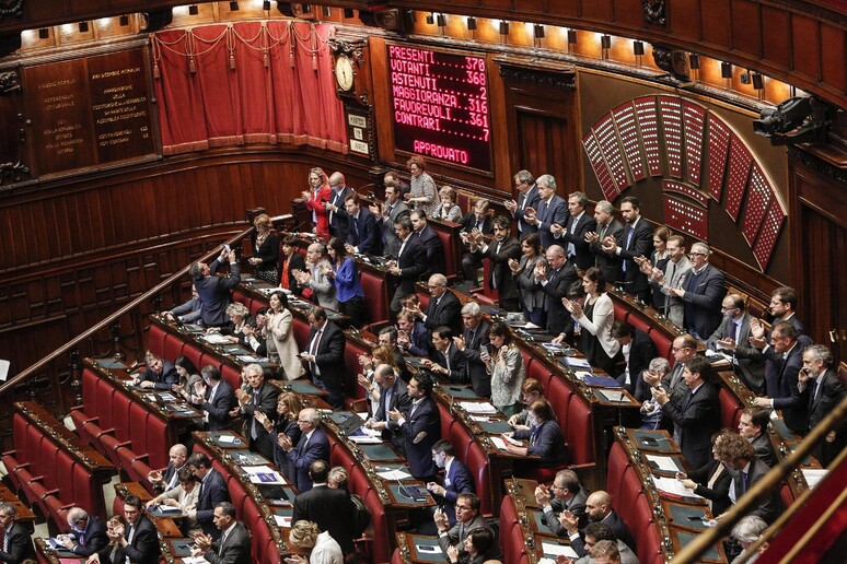L 'emiciclo della maggioranza alla Camera, con i deputati che applaudono dopo il voto finale - RIPRODUZIONE RISERVATA