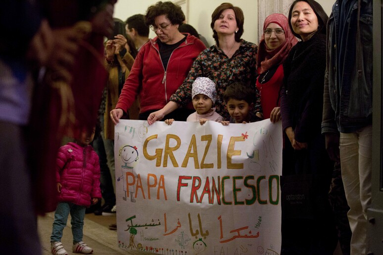 Ospiti della comunità di Sant 'Egidio danno il benvenuto ai rifugiati siriani © ANSA/AP