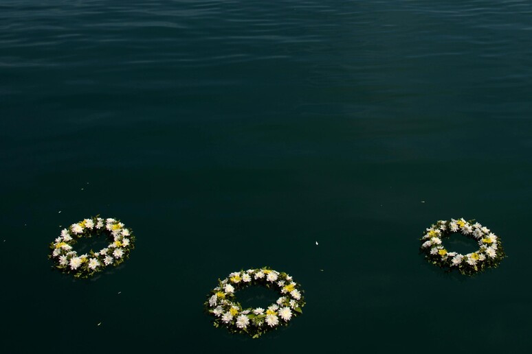 Per fare memoria delle vittime delle migrazioni, nel porto di Mitilene, a Lesbo, lanciate corone di alloro in mare © ANSA/EPA