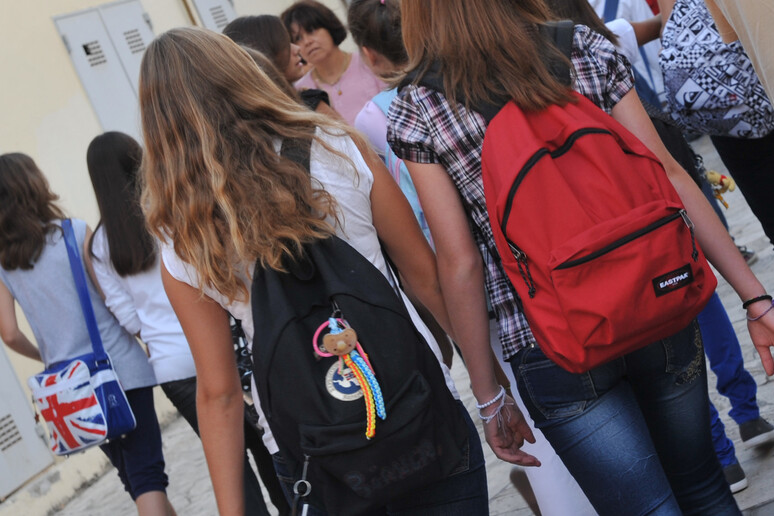 Due ragazze, zaini in spalla, all 'ingresso di una scuola media a Pisa in una foto di archivio - RIPRODUZIONE RISERVATA
