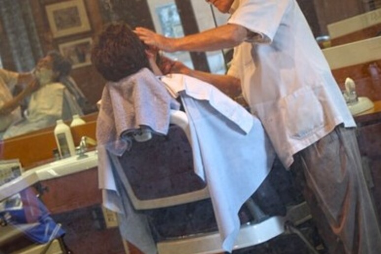 Un barbiere al lavoro - RIPRODUZIONE RISERVATA