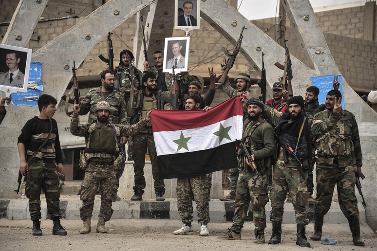 Soldati siriani e miliziani di Hezbollah celebrano la sconfitta dell 'Isis nei pressi di Al-Boukamal, nella zona di Deir Ez Zor (archivio, novembre 2017) © ANSA/EPA