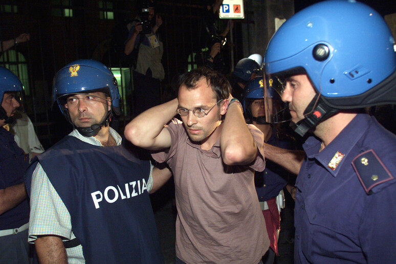 Un giovane fermato al G8 di Genova in una foto d 'archivio del luglio 2001 - RIPRODUZIONE RISERVATA