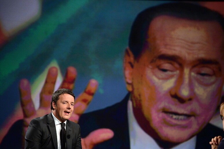 Matteo Renzi durante la trasmissione  'In 1/2 Ora ' condotta da Lucia Annunziata, sullo schermo Berlusconi - RIPRODUZIONE RISERVATA