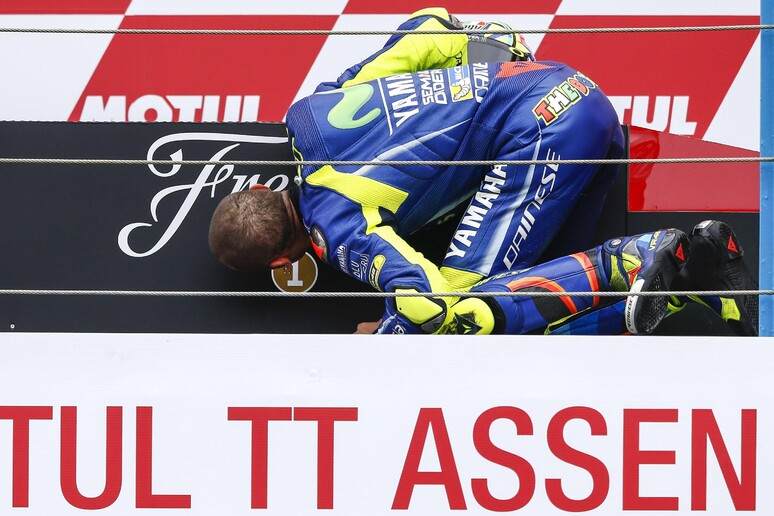 Valentino Rossi bacia il podio dopo la vittoria ad Assen © ANSA/EPA