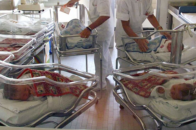 Due infermiere con alcuni neonati in ospedale in una foto d 'ARCHIVIO - RIPRODUZIONE RISERVATA