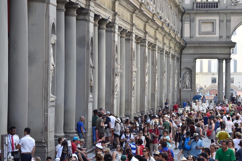 Turisti davanti agli Uffizi in una foto di archivio - RIPRODUZIONE RISERVATA
