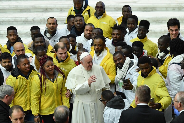 Papa Frabcesco con un gruppo di migranti - RIPRODUZIONE RISERVATA