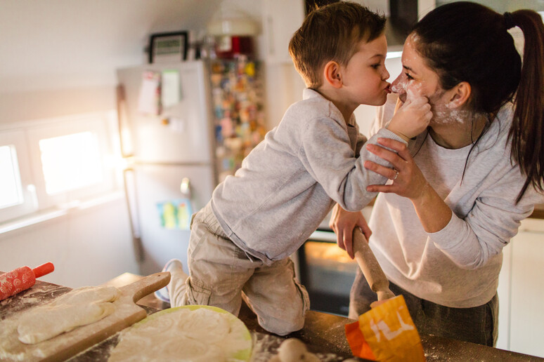 Mamma e figlio, coccole in cucina. foto AleksandarNakic iStock. - RIPRODUZIONE RISERVATA