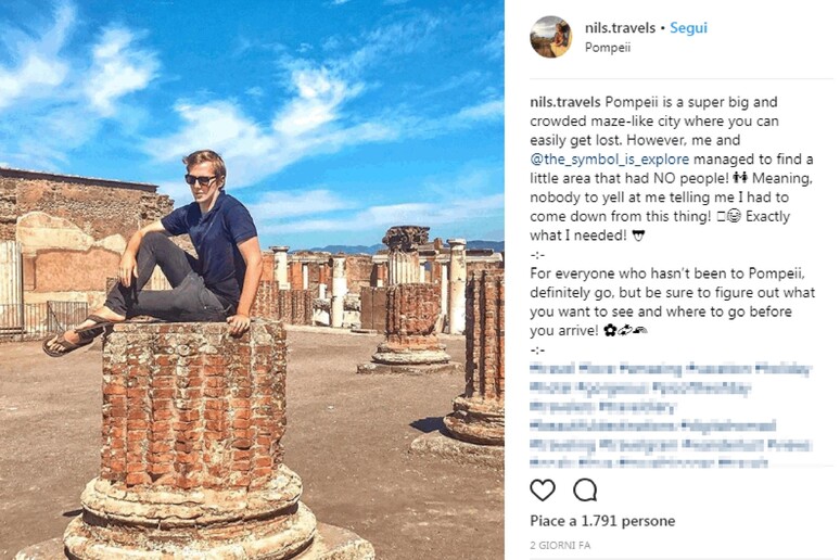 Turista in posa su una colonna degli scavi di Pompei - RIPRODUZIONE RISERVATA