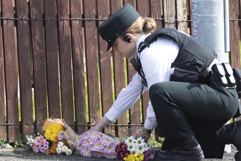 Una poliziotta depone un fiore nel punto in cui è morta Lyra McKee © ANSA/EPA