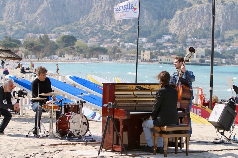 Un momento della registrazione del video sulla spiaggia di Mondello (Foto Vincenzo Baglione) - RIPRODUZIONE RISERVATA