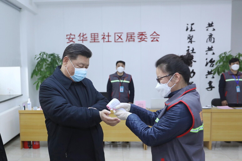 Il presidente cinese Xi Jinping con la mascherina si sottopone alla misurazione della temperatura corporea © ANSA/EPA