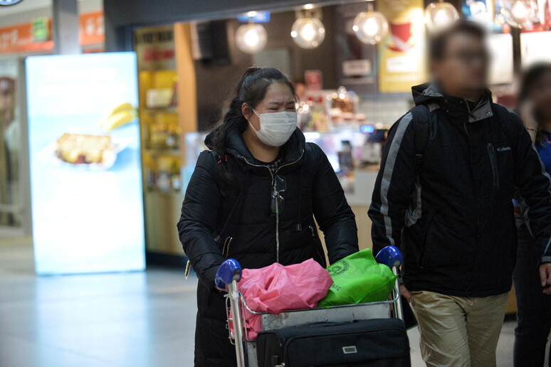 Passeggeri con la mascherina in aeroporto © ANSA/EPA
