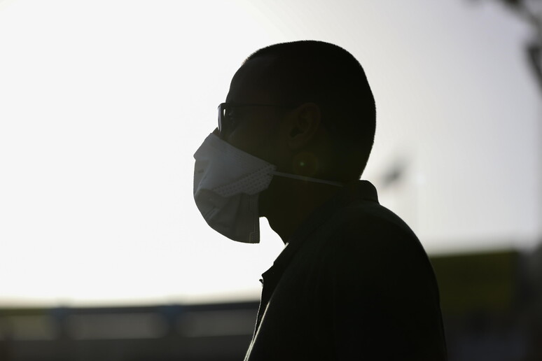 Un uomo indossa la mascherina © ANSA/EPA