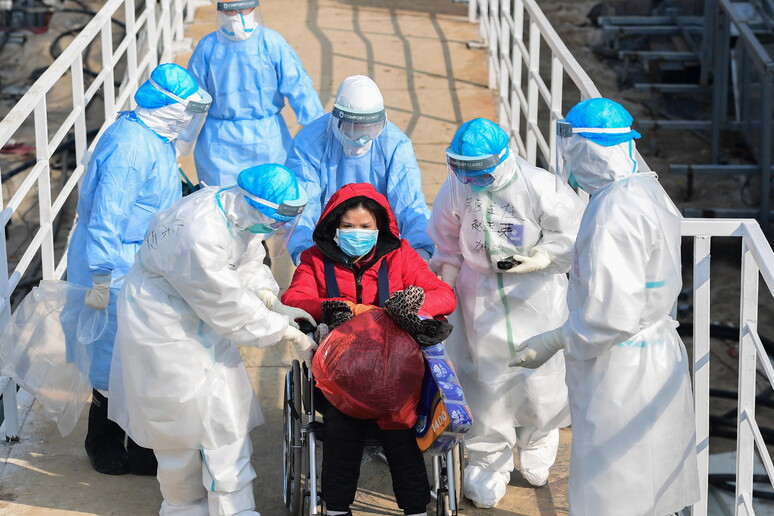 Operatori sanitari soccorrono donna malata a Wuhan © ANSA/EPA