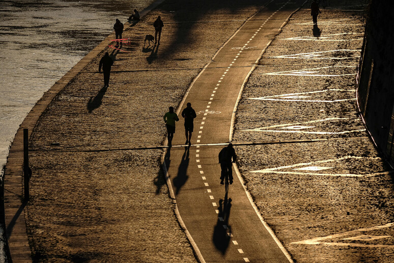Alcune persone passeggiano e fanno sport sull 'argine del Lungo Tevere © ANSA/ANSA/ALESSANDRO DI MEO