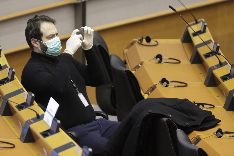 Un membro dell 'Europarlamento durante una seduta indossa una mascherina di protezione © ANSA/EPA
