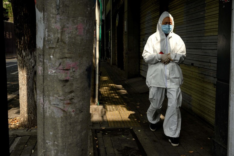 Una donna per le vie di Wuhan © ANSA/AFP