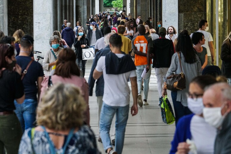 Persone passeggiano e discutono sotto i portici di via Roma, Torino - RIPRODUZIONE RISERVATA