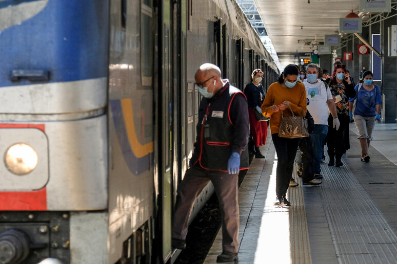 Viaggiatori nella stazione Termini tra segnaletica, cartelli e controlli - RIPRODUZIONE RISERVATA